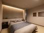 ベッドヘッドの上部の間接照明が部屋をやわらかく照らし、くつろぎの空間に。